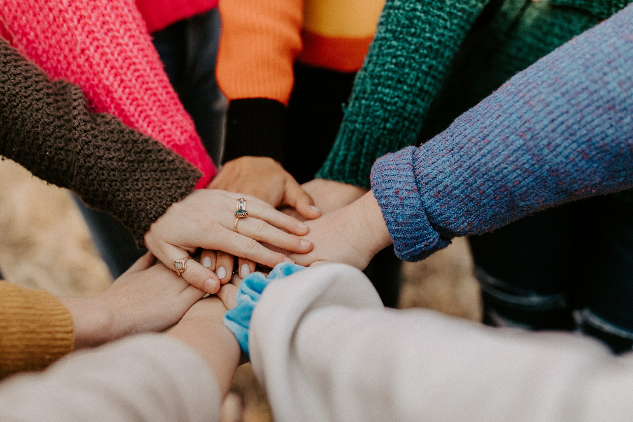 Stock photograph by Hannah Busing of a group of people's hands, placed one on top of the other to create a "go-team!" hand-stack.